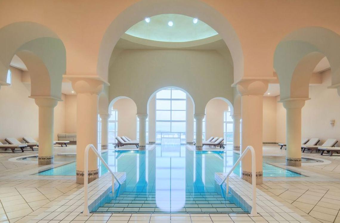 Innenpool des Ulysse Djerba Thalasso & Spa mit weißen Fliesen und blauem Wasser