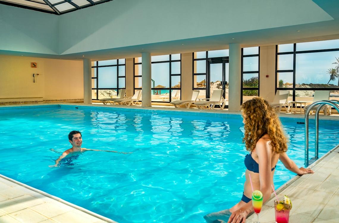 Ein Schwimmbad mit Gästen im Ulysse Djerba Thalasso & Spa Hotel.