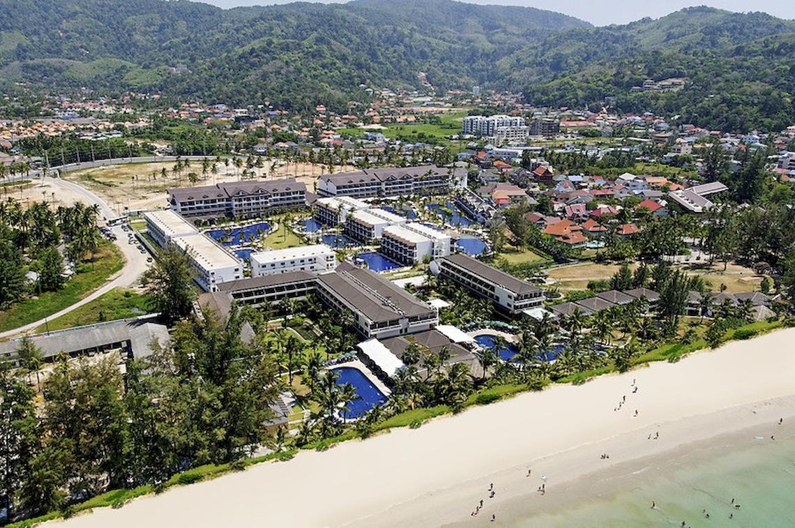 Luftaufnahme des Sunwing Kamala Beach Hotels mit mehreren Swimmingpools und einem langen Strand.