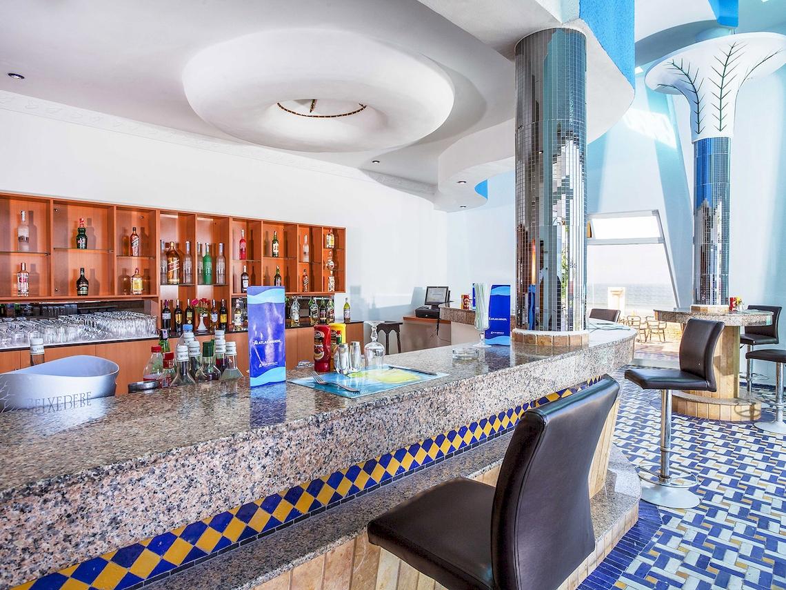 Die Bar im Atlas Amadil Beach Hotel mit Granittheke und blau-gelbem Bodenmuster.