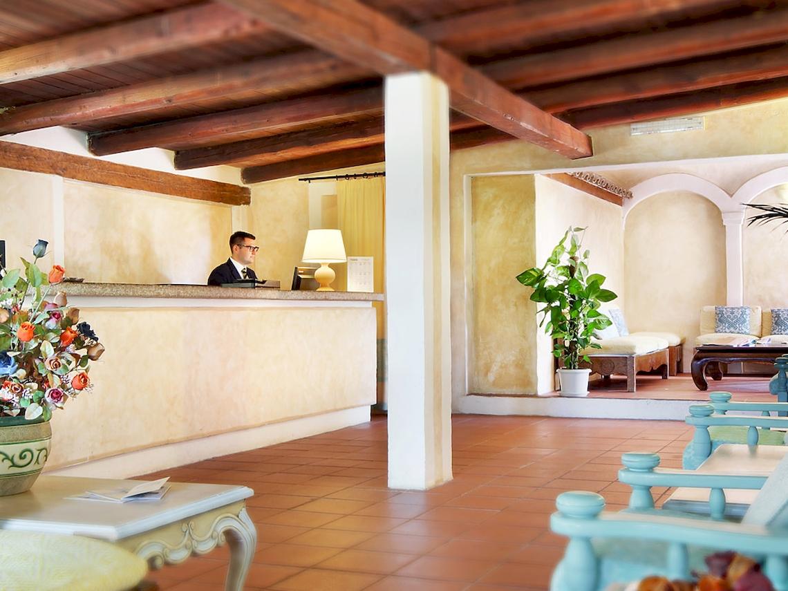 Rezeption des Colonna Hotel Du Golf mit Angestelltem und Innenraumdesign.