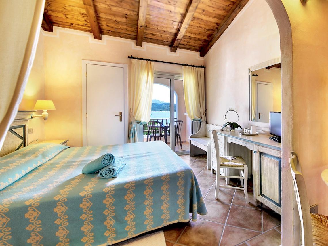Colonna Hotel Du Golf Schlafzimmer mit Balkon, Bett, Schreibtisch und Meerblick.