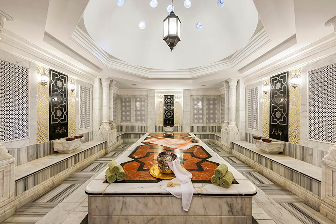 Innenansicht des Spas im Rixos Sharm El Sheikh Hotel mit Marmorboden, gemusterten Wänden und einer zentralen Liegefläche.