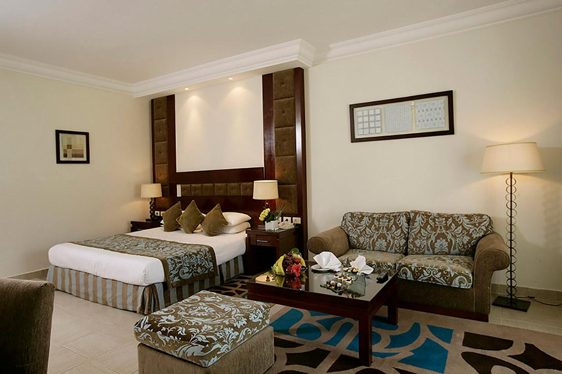 Hotelzimmer mit Doppelbett, Sofa, Tisch und Lampe im Rixos Sharm El Sheikh