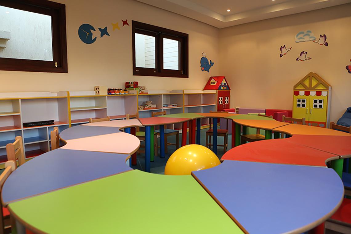 Kinderzimmer im Rixos Sharm El Sheikh mit bunten Tischen, Stühlen und Spielzeug.