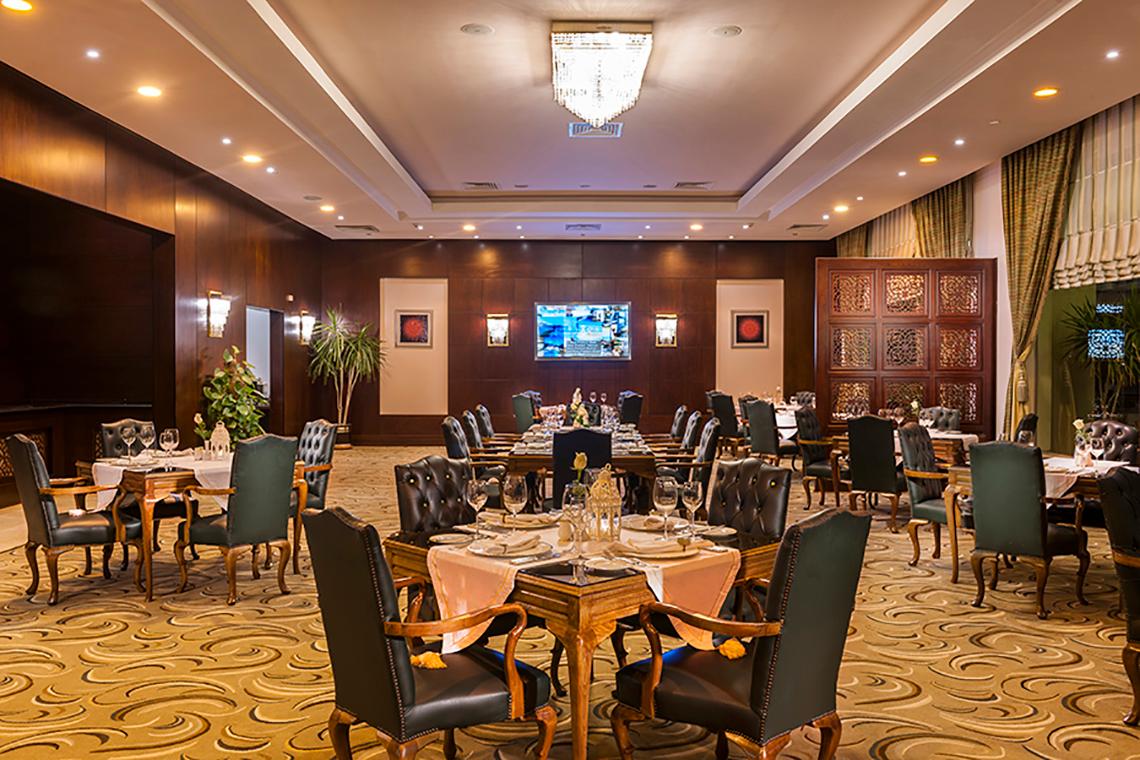 Innenansicht des Restaurants im Rixos Sharm El Sheikh Hotel mit gedeckten Tischen und Stühlen.