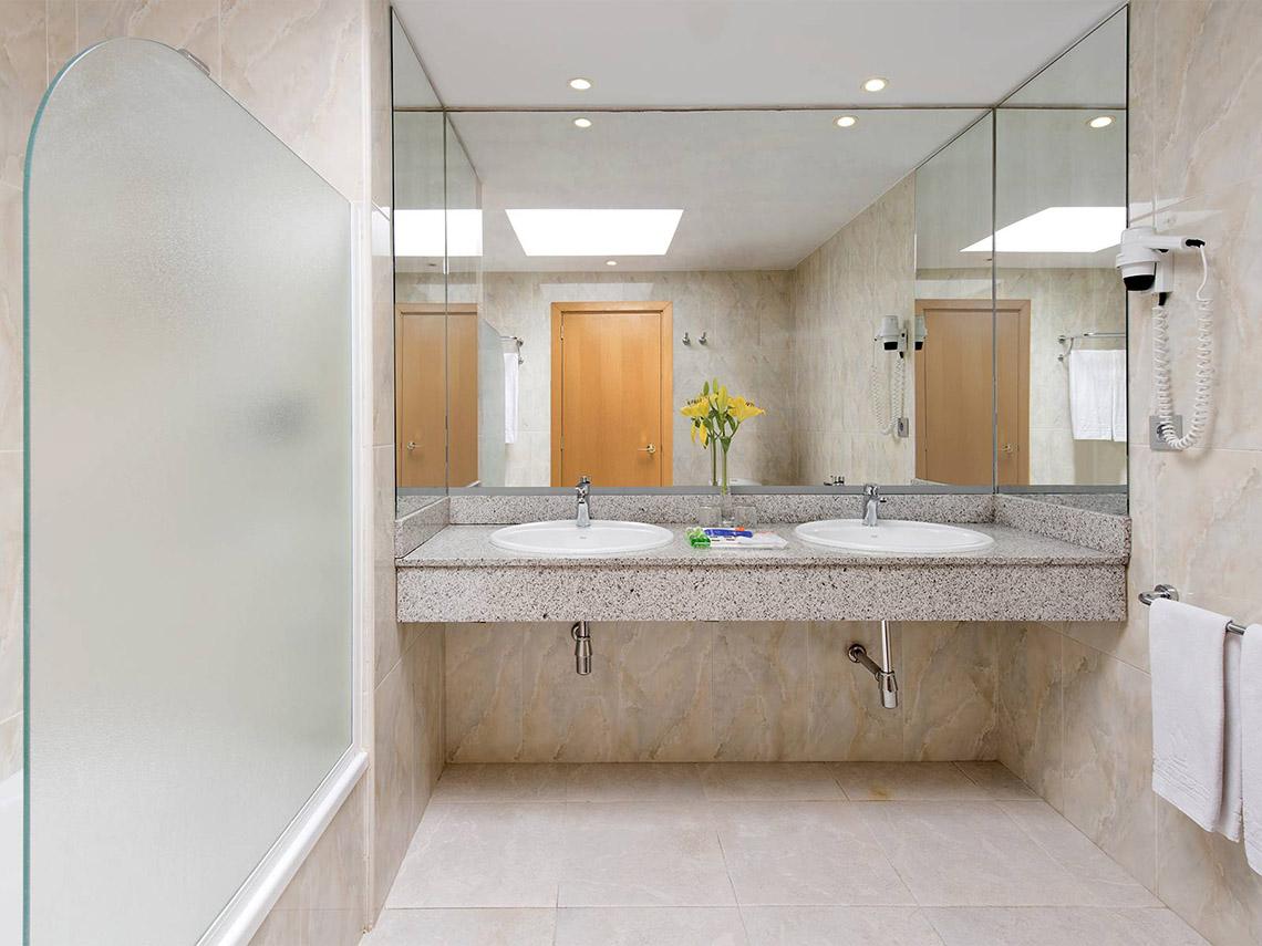 Badezimmer im Tabaiba Princess Hotel mit zwei Waschbecken, Spiegeln und Dusche.