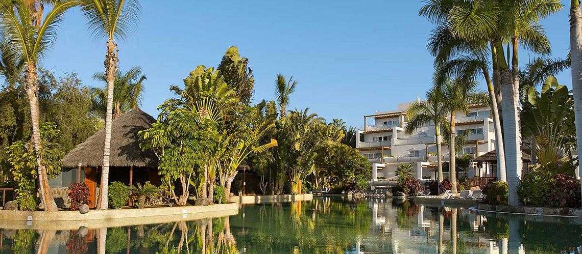 Außenbereich des Tabaiba Princess Hotels mit Swimmingpool und umgeben von Palmen und Pflanzen