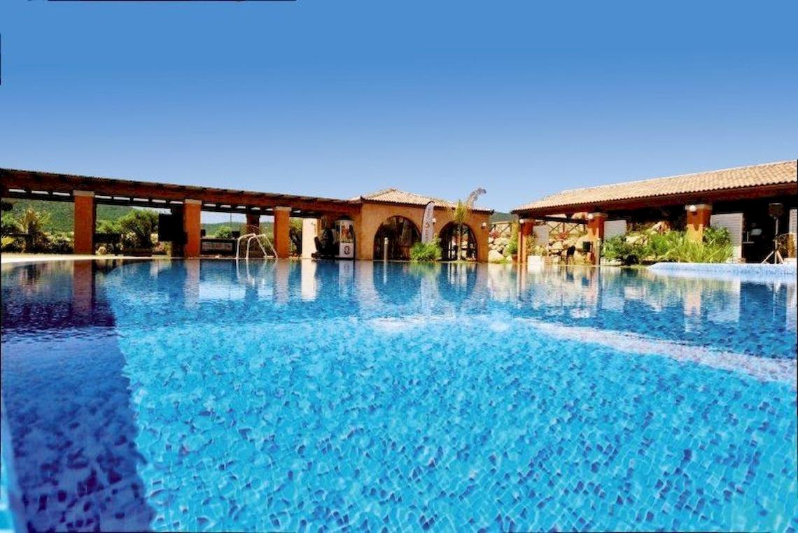Außenpool des Alma Resorts mit blauem Wasser und umliegenden Gebäuden