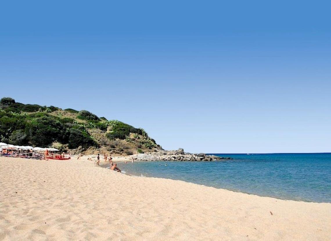 Strand am Alma Resort mit Gästen, die sich entspannen und ins Wasser gehen.