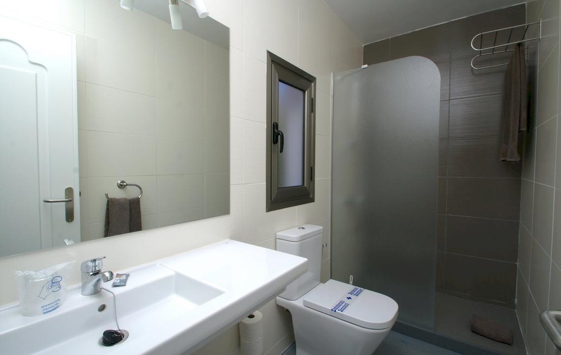 Badezimmer im Turbo Club mit Spiegel, Waschbecken, Toilette und Duschkabine.