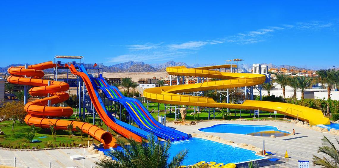 Wasserrutschen im Pickalbatros Royal Moderna Resort mit Swimmingpool im Hintergrund.