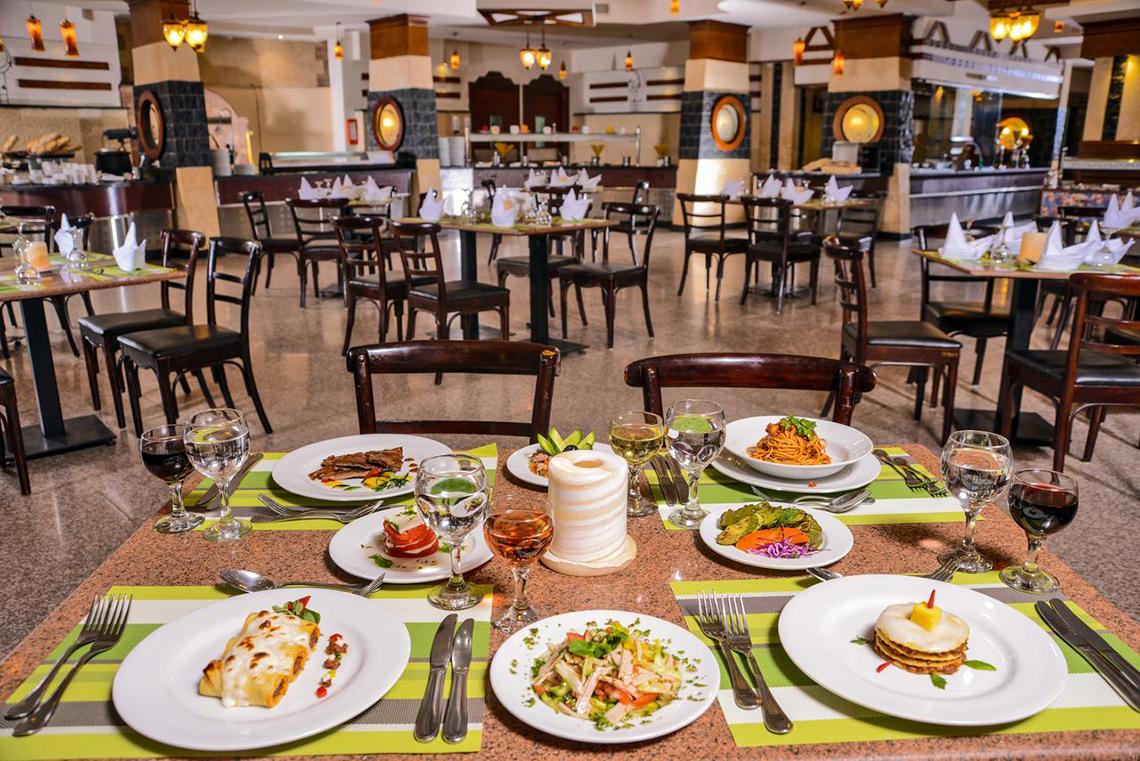 Restaurant im Pickalbatros Royal Moderna Resort mit gedeckten Tischen und Speisen.