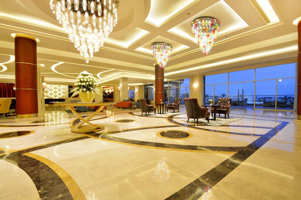 Empfangshalle des Pickalbatros Royal Moderna Resort mit großen Kronleuchtern und Marmorboden.
