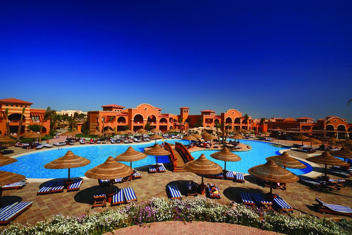 Außenbereich des Pickalbatros Royal Moderna Resort mit Swimmingpool, Sonnenliegen und Sonnenschirmen.