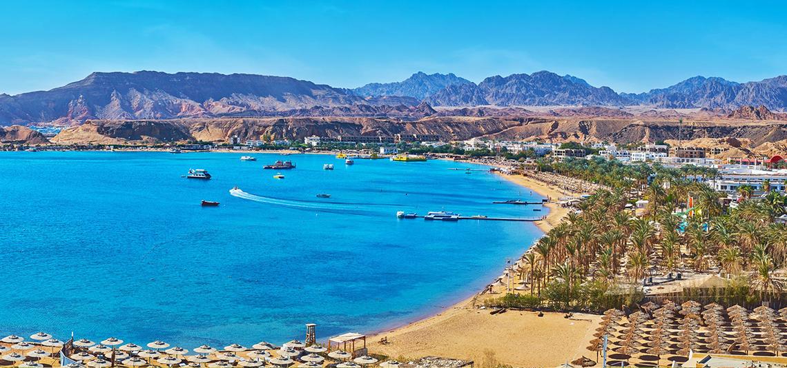 Luftaufnahme des Pickalbatros Royal Moderna Resorts in Sharm el Sheikh mit blauem Wasser, Bergen und vielen Booten