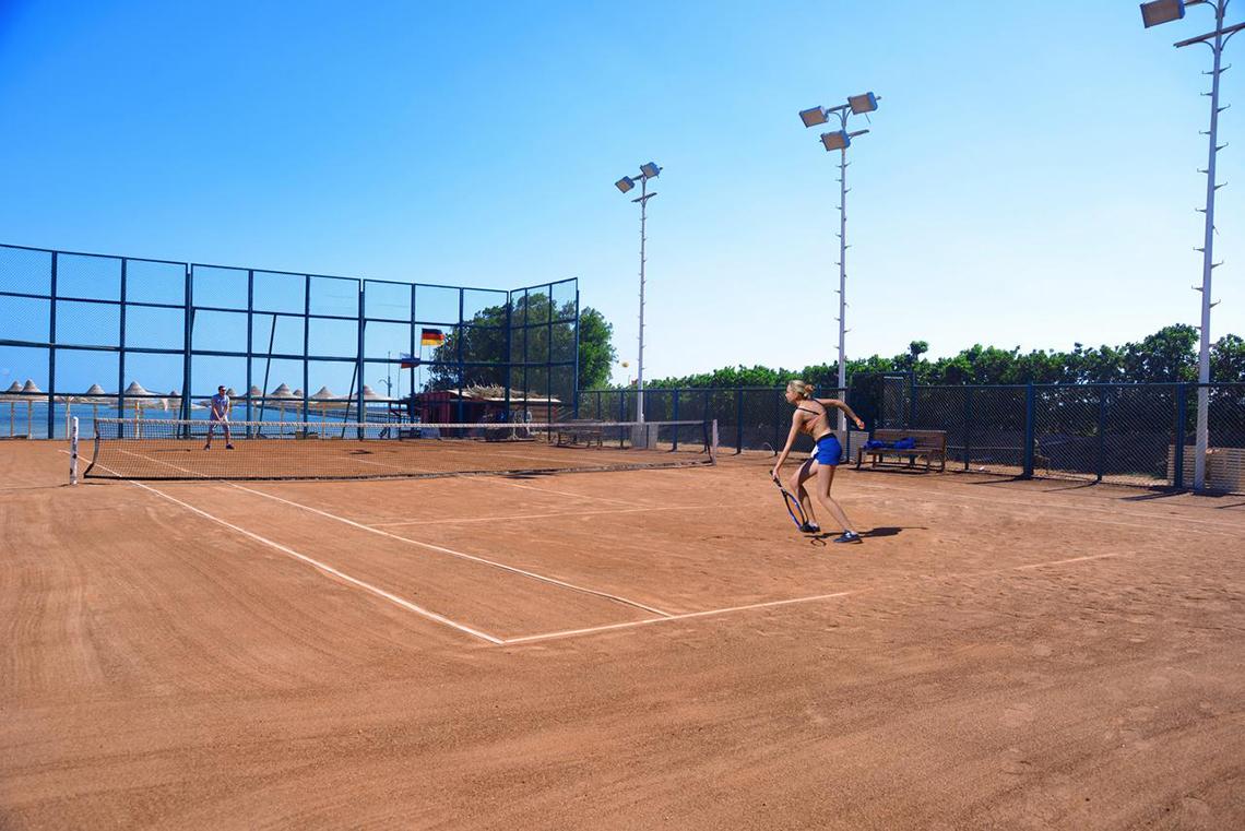 Tennisplatz im Pickalbatros Royal Moderna Resort mit einer Spielerin und einem Netz.