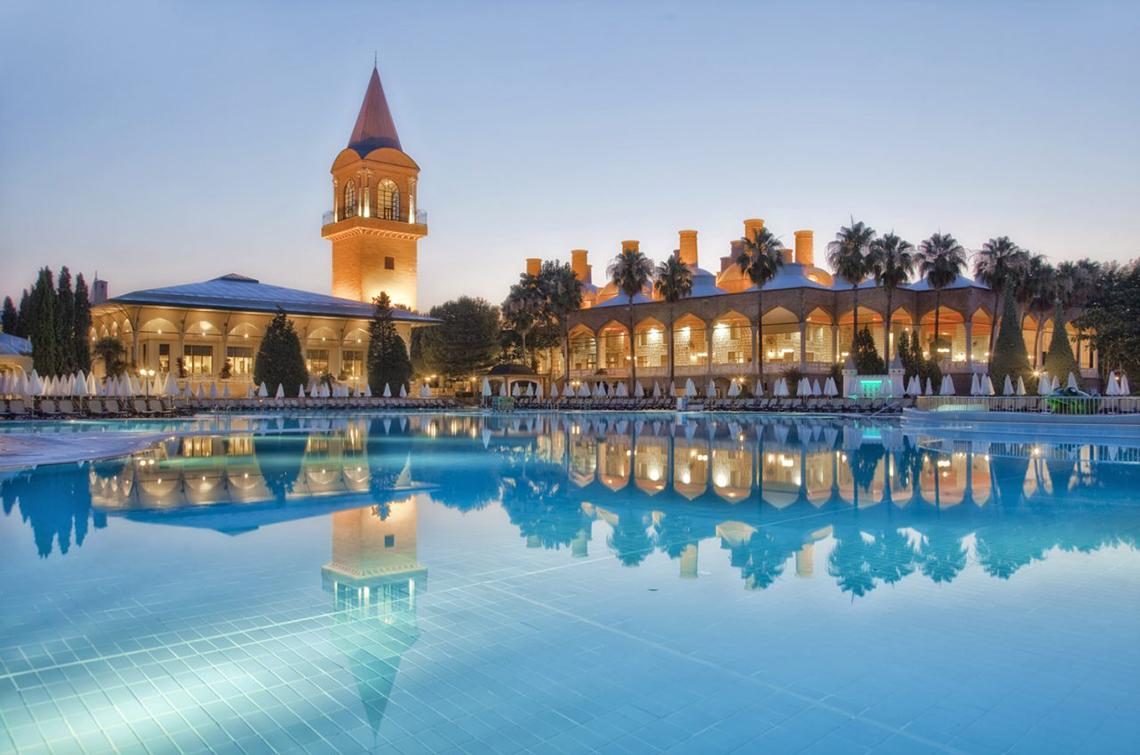 Außenbereich des Swandor Hotels & Resorts Topkapi Palace mit großem Pool und Gebäude im Hintergrund