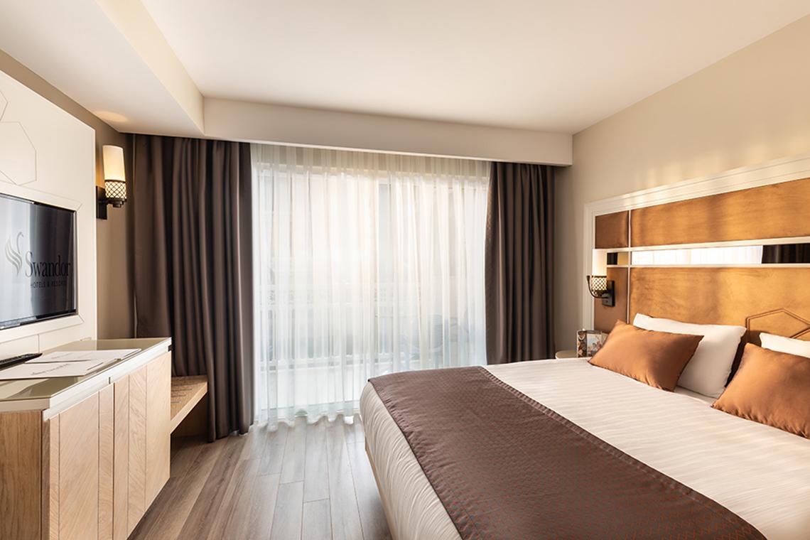 Schlafzimmer im Swandor Hotels & Resorts Topkapi Palace mit Bett, Fernseher und Nachttisch
