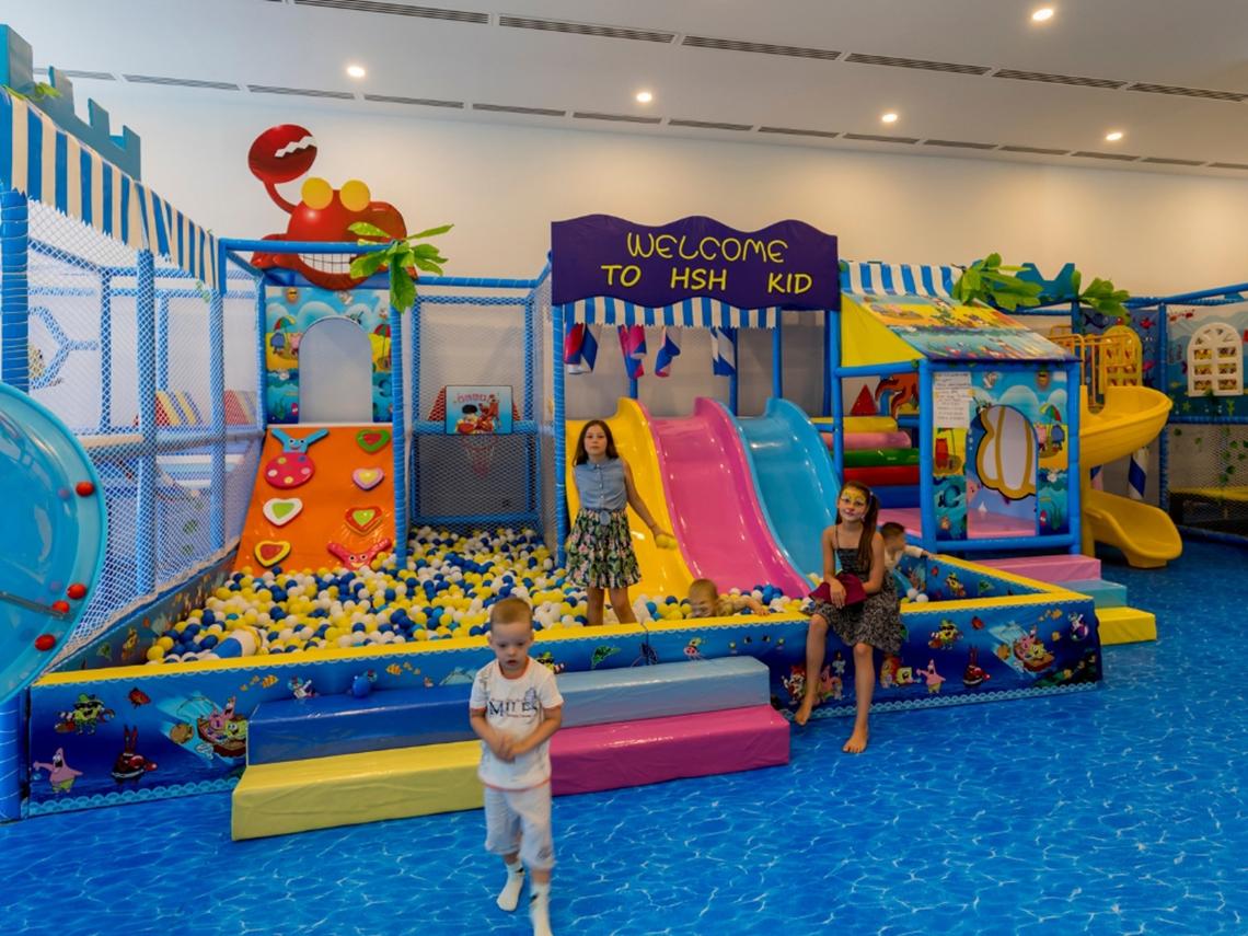 Kinderspielplatz im Swandor Hotels & Resorts Topkapi Palace mit verschiedenen Spielgeräten und Kindern, die spielen.