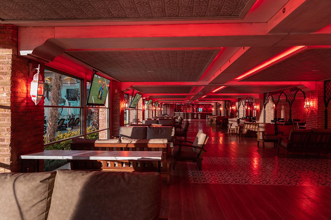 Loungebereich im Swandor Hotels & Resorts Topkapi Palace mit roten Beleuchtungselementen und Sofas.