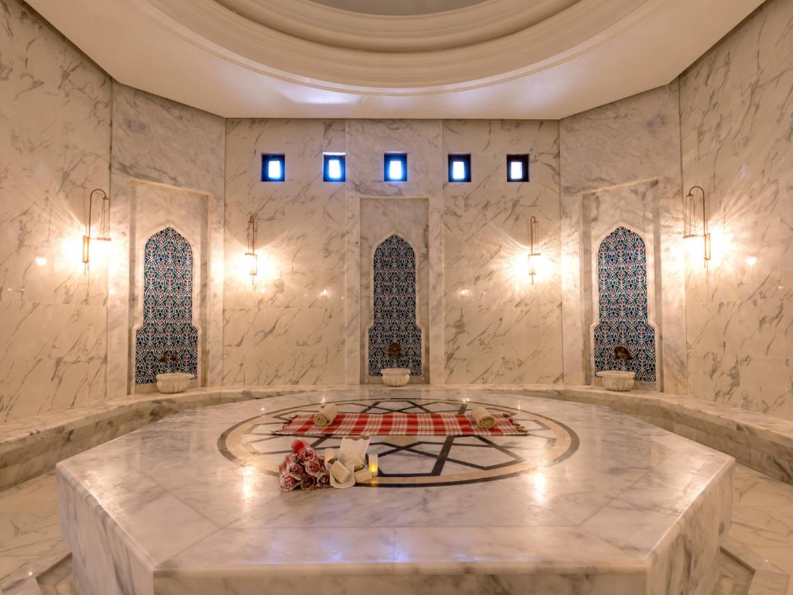 Saunabereich im Swandor Hotels & Resorts Topkapi Palace mit weißen Marmorwänden und zentralen Dekorationen.