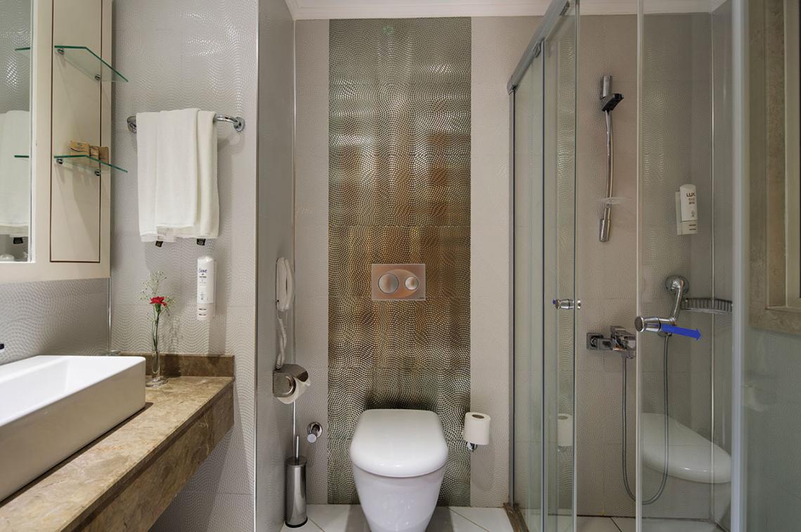 Badezimmer im Crystal Waterworld Aqua Collection Hotel mit Dusche, Toilette und Waschbecken.