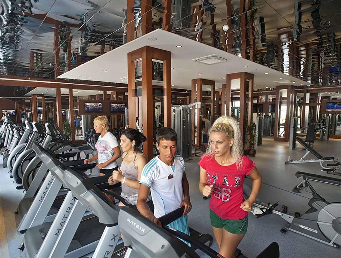 Fitness Center im Crystal Waterworld Aqua Collection Hotel mit Personen auf Laufbändern.
