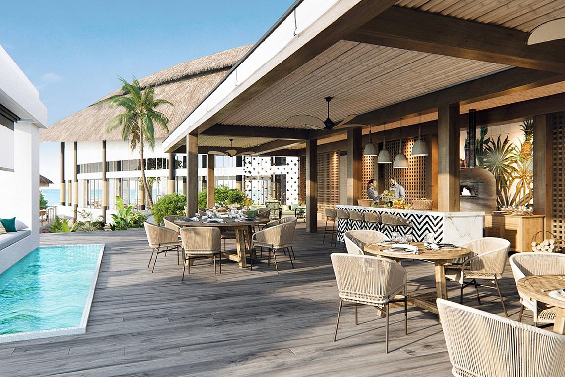 Außenpoolbereich des JW Marriott Maldives Resort & Spa mit Tischen und Stühlen
