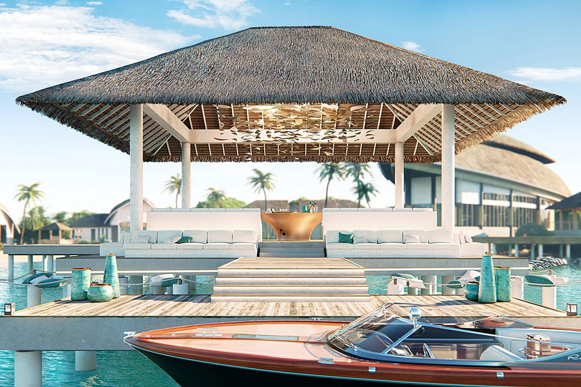 Außenbereich des JW Marriott Maldives Resort mit einer überdachten Terrasse und weißen Möbeln am Wasser.