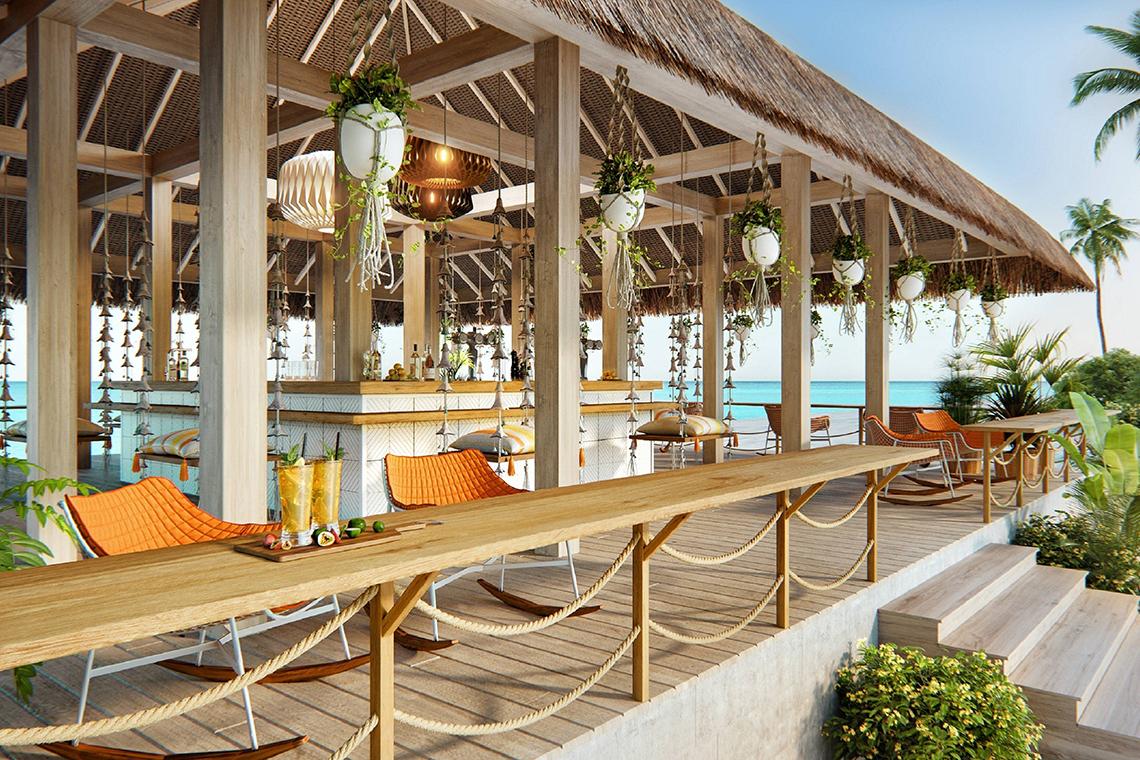 Außenterrasse des JW Marriott Maldives Resort & Spa mit orangen Stühlen und einem Blick auf das Meer.