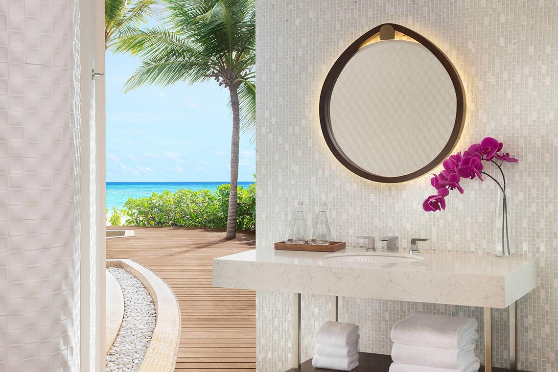 Badezimmer des JW Marriott Maldives Resort & Spa mit Aussicht auf den Ozean und Palmen