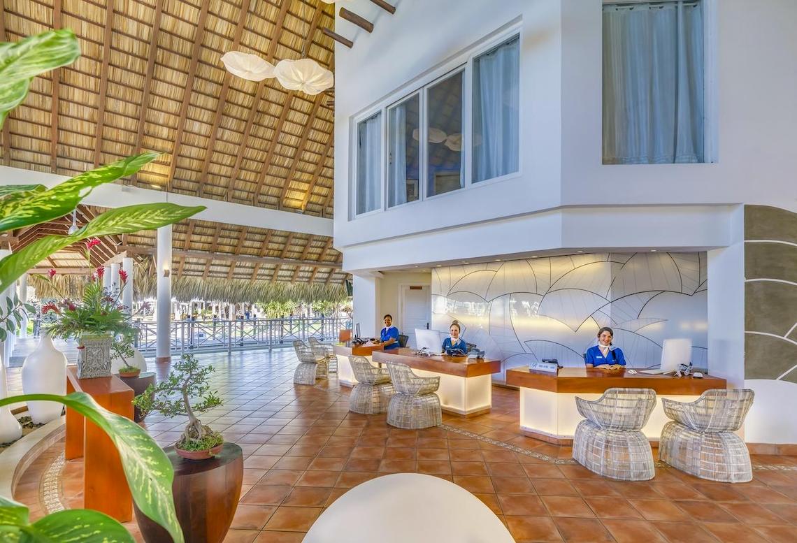 Empfangsbereich des Royalton Hicacos Resort & Spa mit Rezeptionistinnen an Schreibtischen.