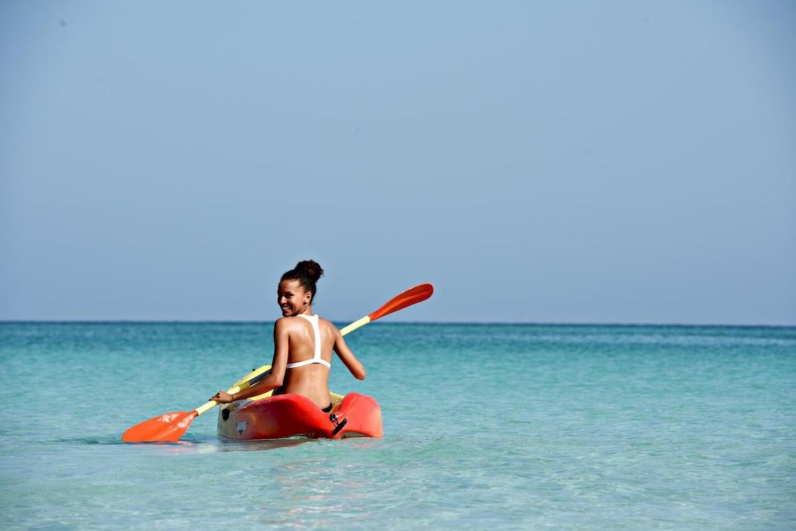 Frau im Kajak im Meer mit einem Lächeln auf dem Gesicht