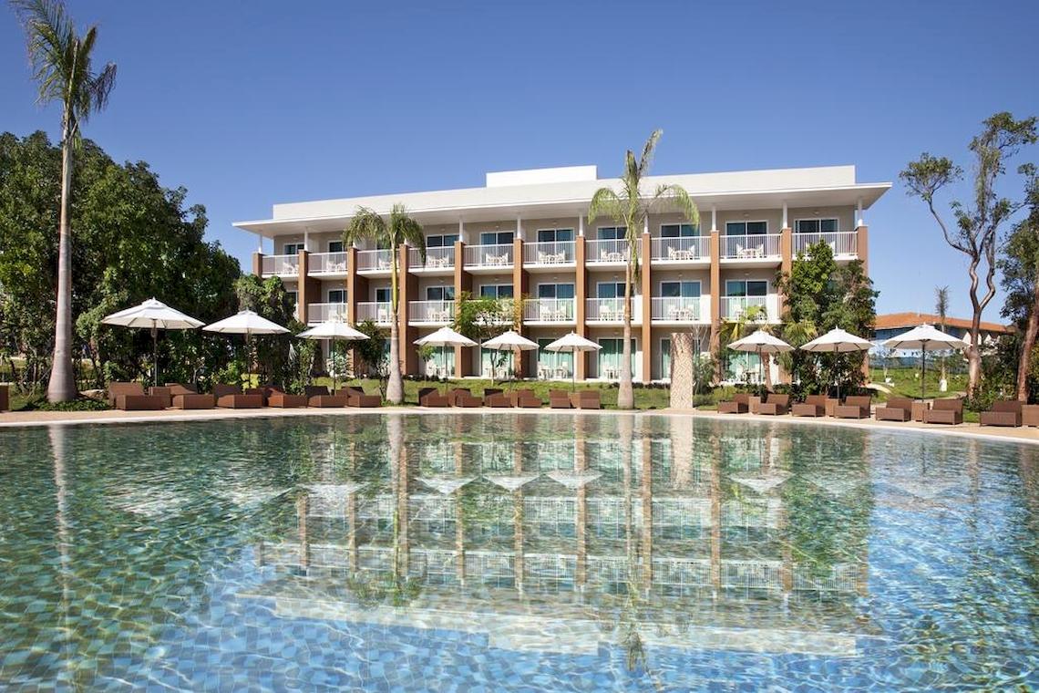 Außenansicht des Royalton Hicacos Resort & Spa mit Swimmingpool und Sonnenliegen.