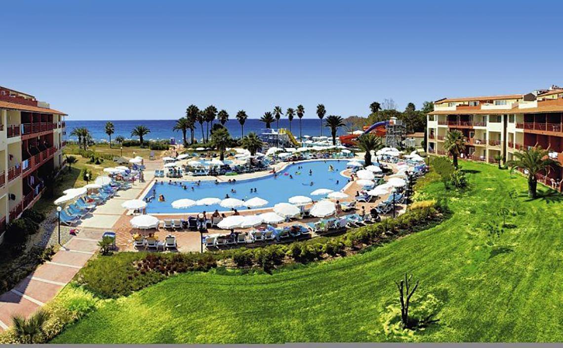 Außenbereich des Ephesia Holiday Beach Club Resorts mit Pool, Liegestühlen und Sonnenschirmen
