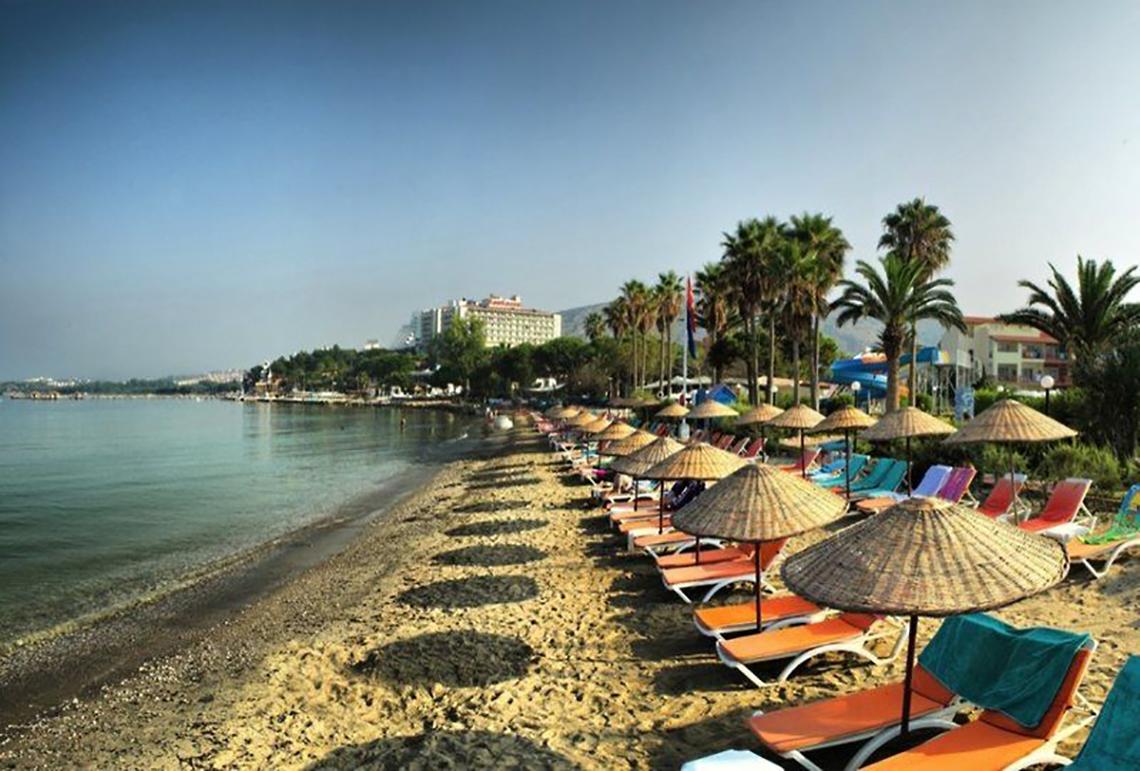 Strand des Ephesia Holiday Beach Club mit vielen Liegestühlen und Sonnenschirmen.