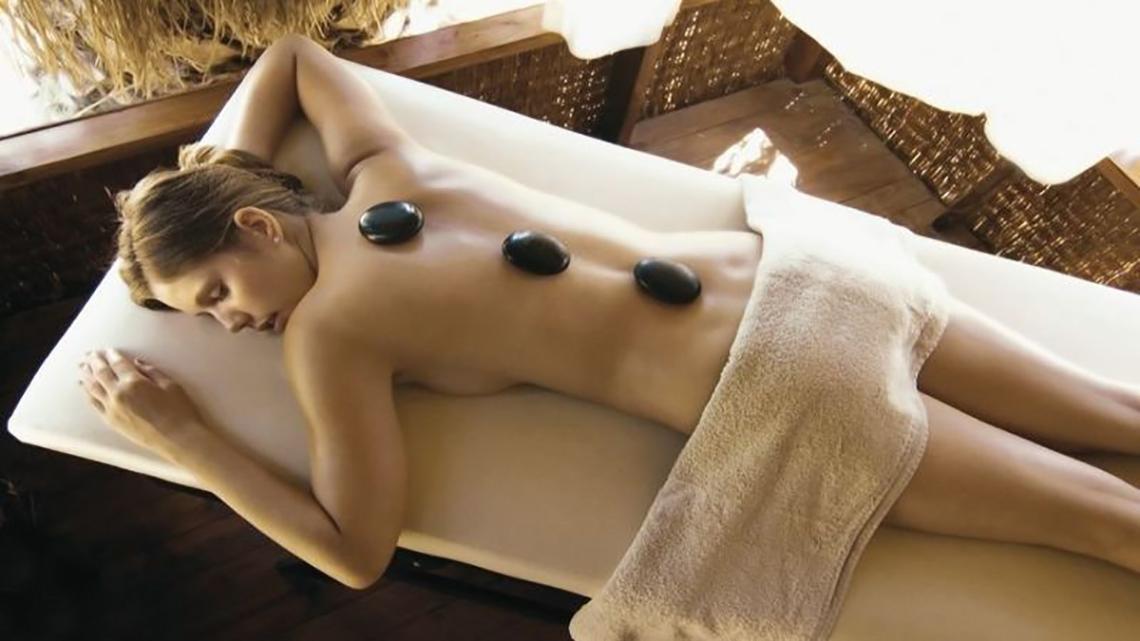 Frau genießt eine Steinmassage im Ephesia Holiday Beach Club Hotel Spa.