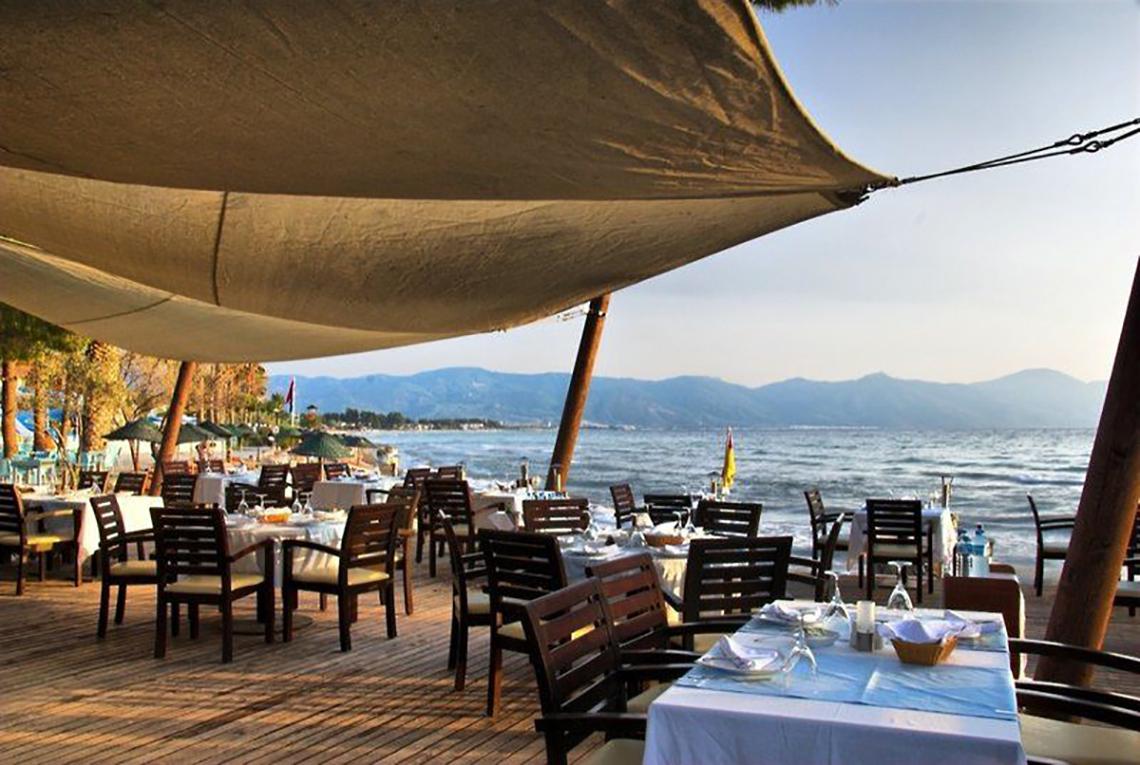 Essenbereich im Freien im Ephesia Holiday Beach Club mit Blick auf das Meer