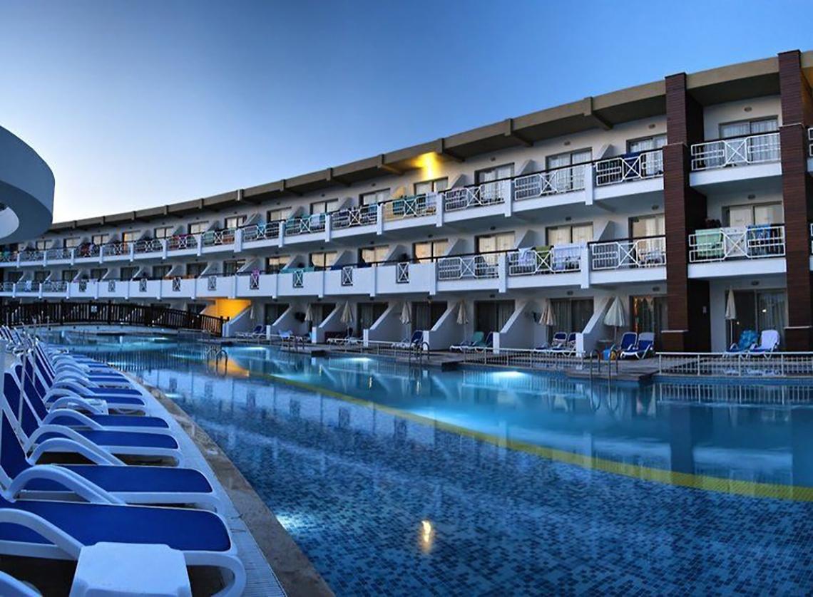 Außenpool des Ephesia Holiday Beach Club Hotels mit vielen Sonnenliegen und geräumigen Balkonen.