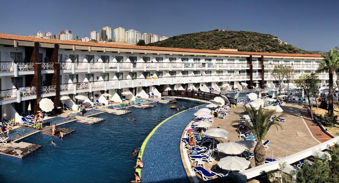 Außenansicht des Ephesia Holiday Beach Club Hotels mit Swimmingpool und Sonnenliegen.