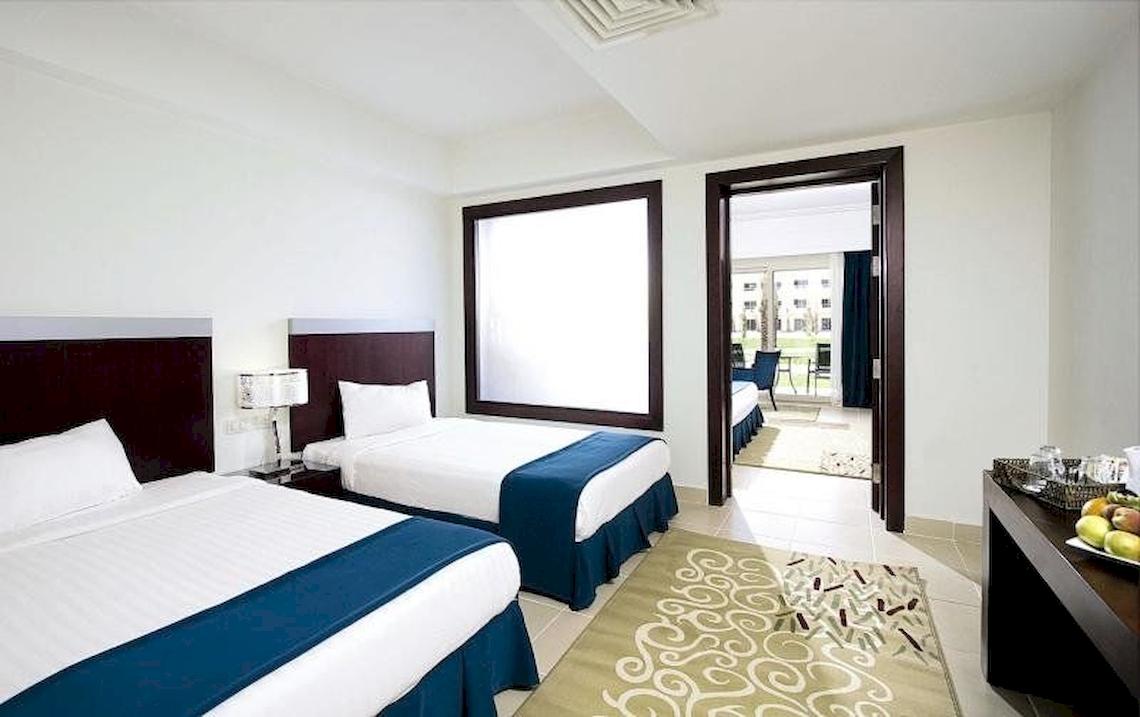 Doppelbett-Zimmer im Serenity Alma Heights Hotel mit Blick auf die Außenterrasse.