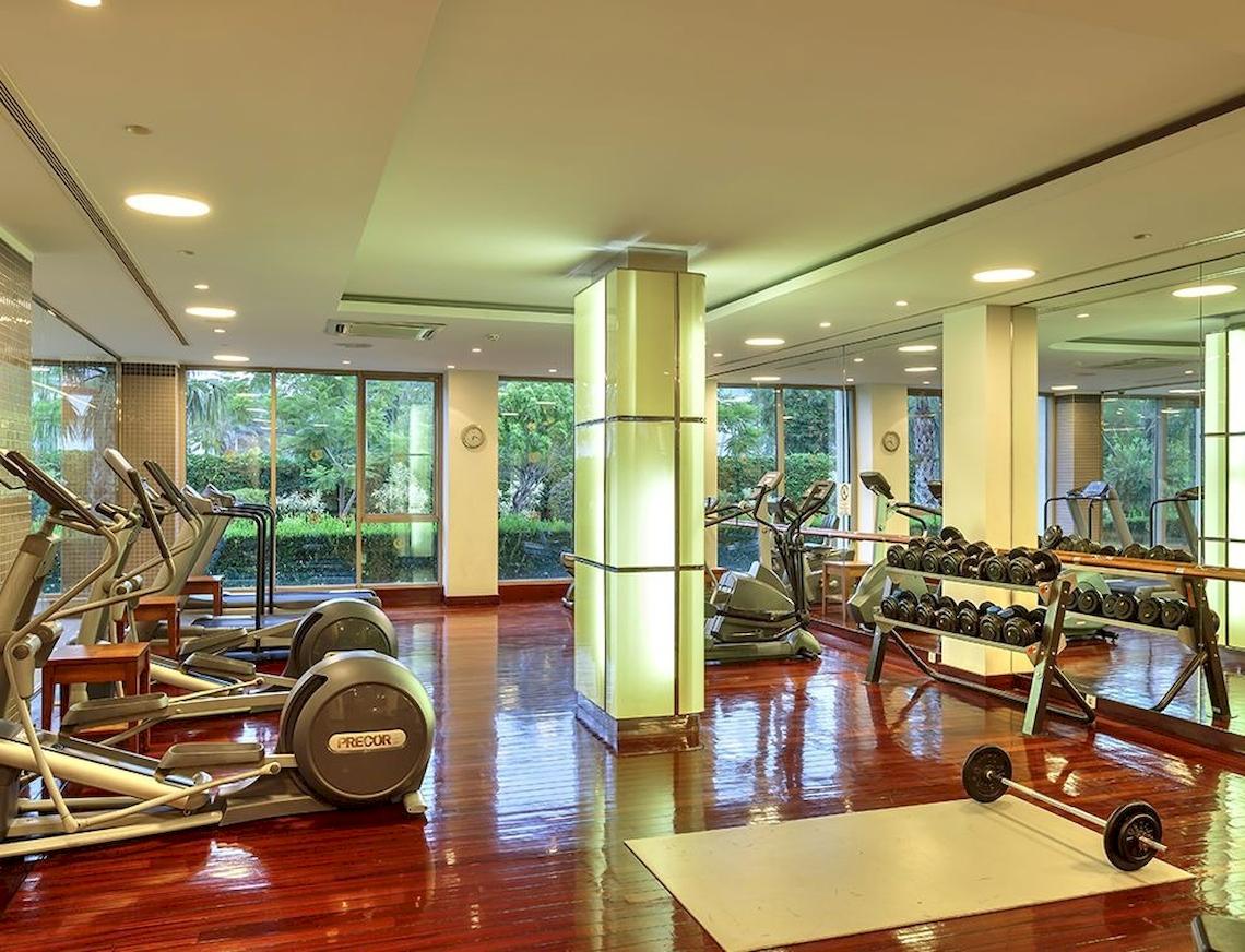 Innenansicht des Fitness-Centers des Sunis Elita Beach Resort Hotel & Spa mit Laufbändern, Hanteln und anderen Geräten.