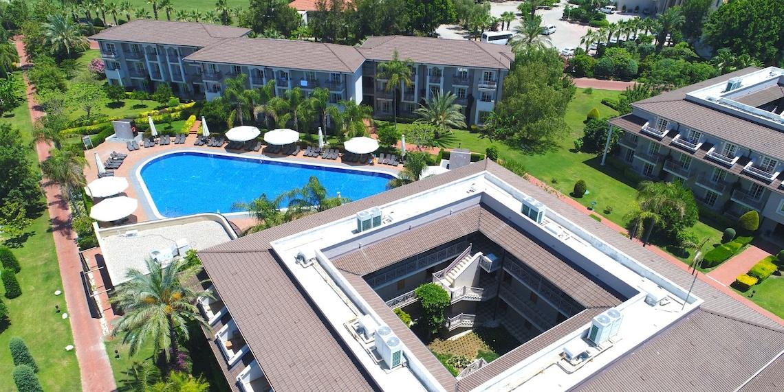 Luftaufnahme des Sunis Elita Beach Resort Hotel & Spa mit Swimmingpool und Sonnenliegen.