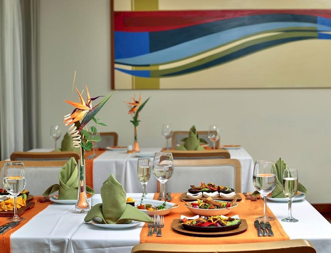 Ein elegantes Esszimmer im Sunis Elita Beach Resort Hotel & Spa mit gedeckten Tischen und Speisen.