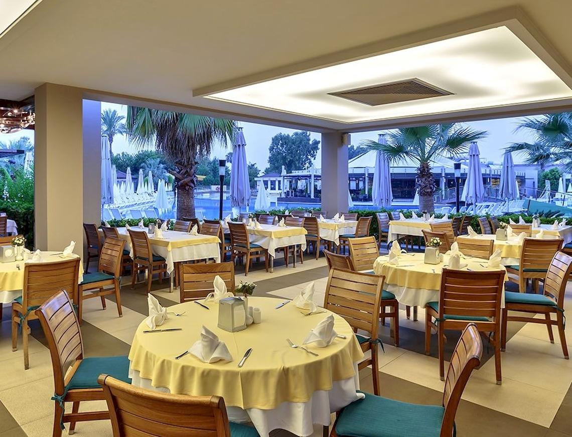 Innenansicht des Restaurants im Sunis Elita Beach Resort Hotel & Spa mit Blick auf den Pool.