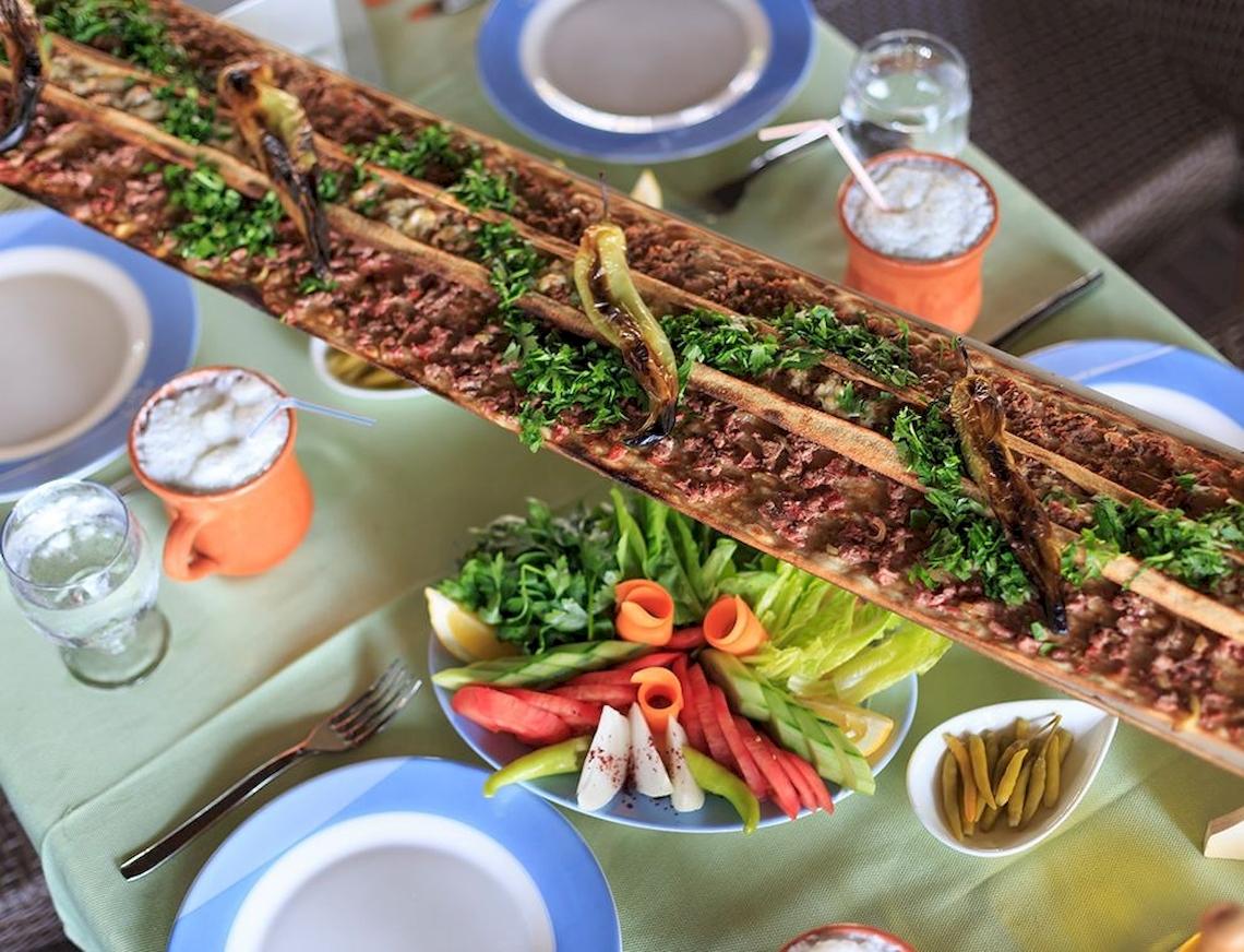 Ein Tisch mit Essen, Getränken und Salat, serviert im Sunis Elita Beach Resort Hotel & Spa.