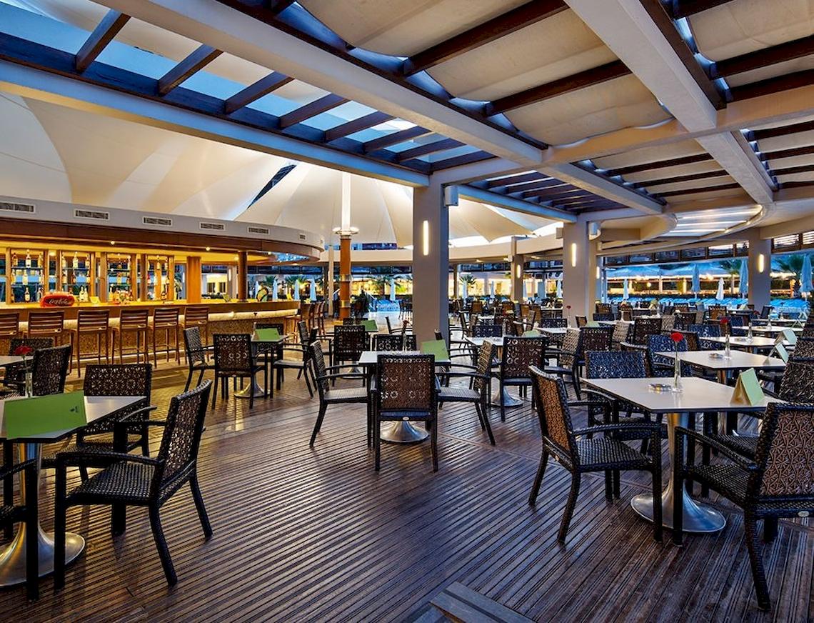 Innenbereich des Sunis Elita Beach Resort Hotel & Spa mit vielen Tischen und Stühlen.