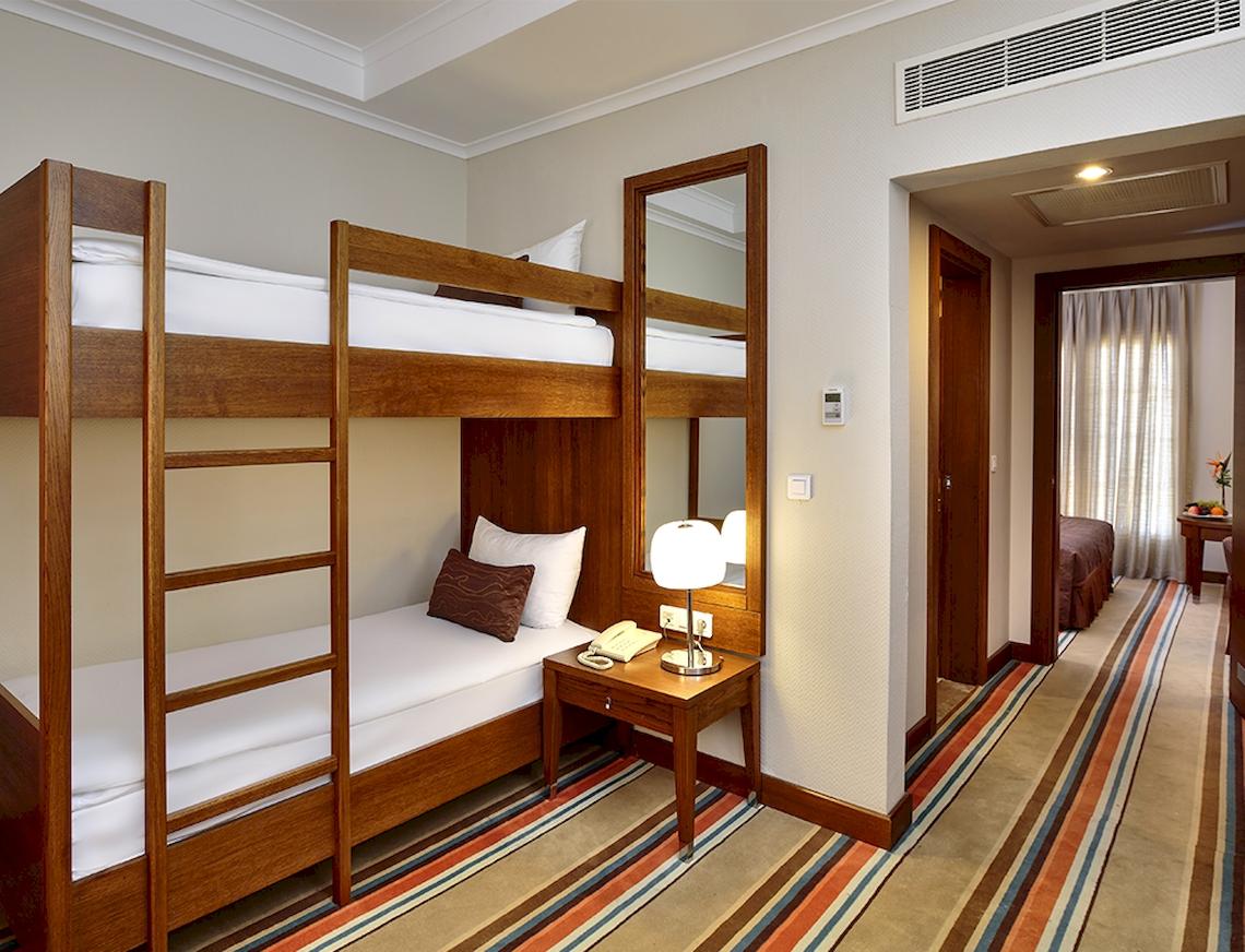 Doppelstockbett im Hotelzimmer mit Nachttisch und Lampe.