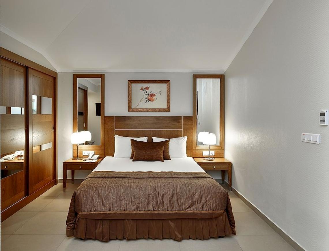 Hotelzimmer im Sunis Elita Beach Resort Hotel & Spa mit Doppelbett, Lampen und Gemälde